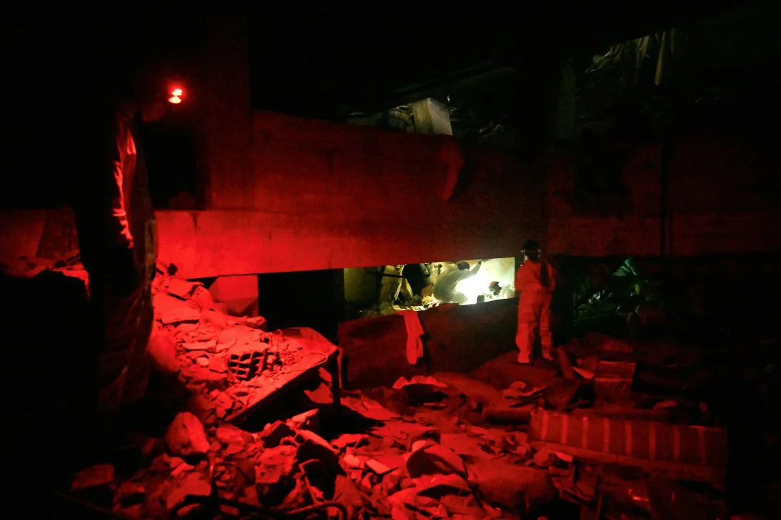 Volunteer rescuers wearing biohazard suits search amid the rubble in the basement of a collapsed building at the Caribbean Residence in Caraballeda, La Guaira state, Venezuela, on September 25. three months after the 7.2 and 7.5-magnitude earthquakes.