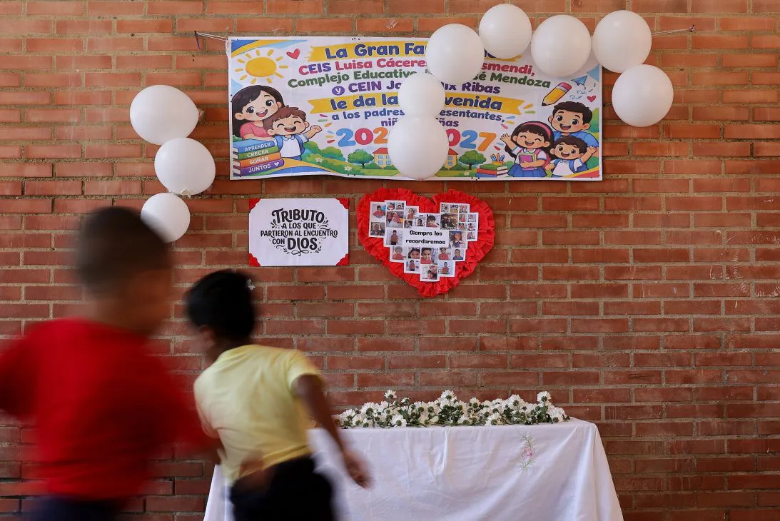 Children at a preschool in La Guaira run past a memorial displaying photographs of students and teachers who died in the earthquake, as classes resume on September 14.