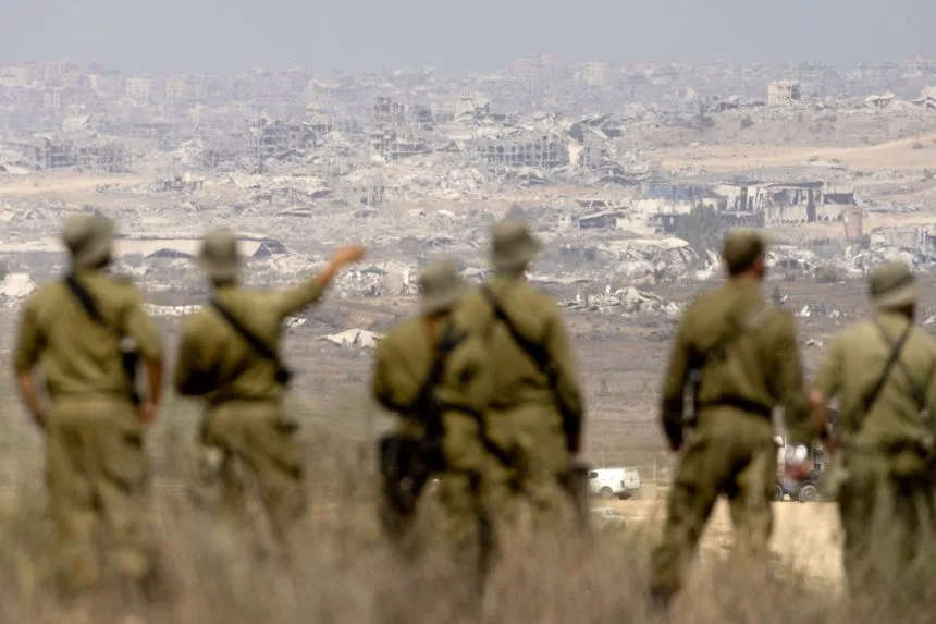Israeli soldiers look across to northern Gaza from a viewpoint on the Israeli side of the border on August 13, 2025.